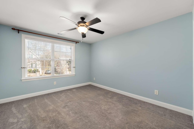 carpeted empty room with a ceiling fan and baseboards