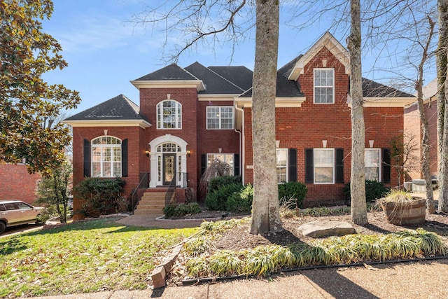 view of front of home with brick siding and a front yard