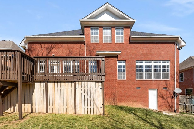 back of house featuring a deck, a yard, and brick siding