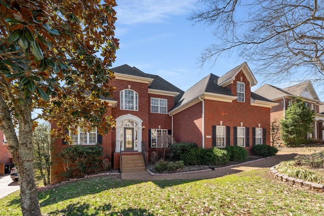 view of front of home featuring brick siding and a front lawn