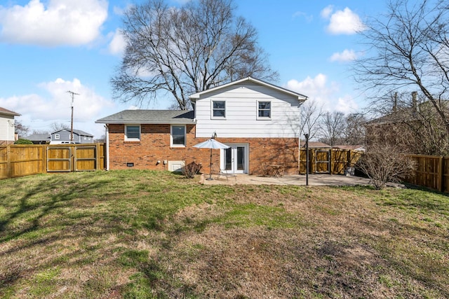 back of property featuring brick siding, a patio, a lawn, a gate, and a fenced backyard