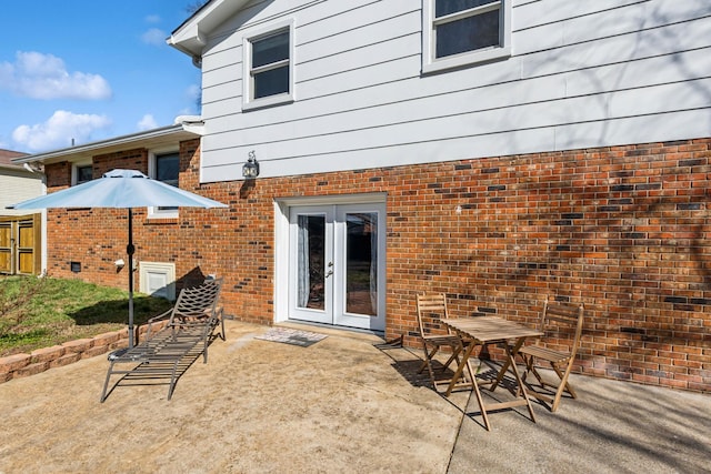 back of property featuring a patio, brick siding, and french doors