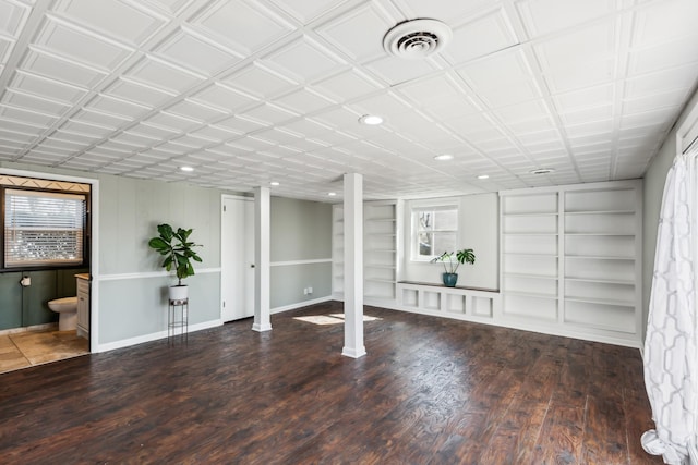 basement featuring wood finished floors, visible vents, and built in features