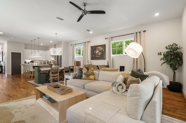 living room featuring recessed lighting, wood finished floors, a ceiling fan, baseboards, and visible vents