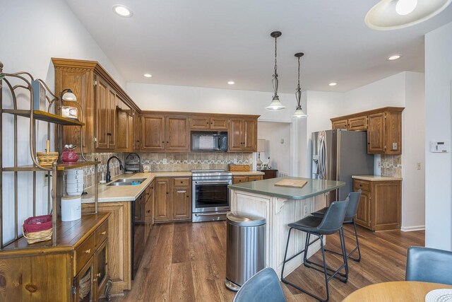 kitchen with black appliances, a kitchen island, dark wood-style floors, and a sink