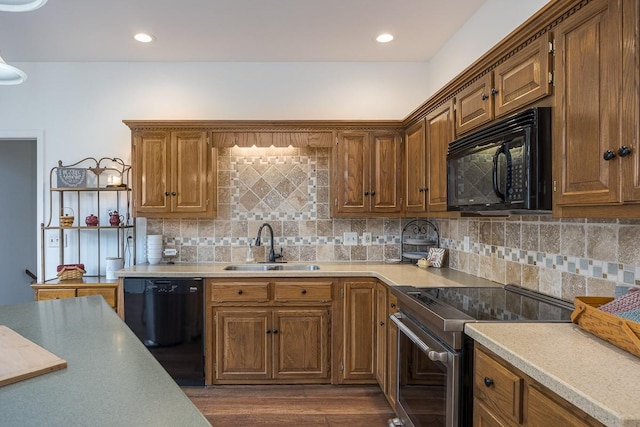 kitchen with recessed lighting, a sink, light countertops, backsplash, and black appliances