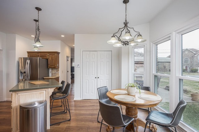 dining space featuring dark wood-type flooring, recessed lighting, baseboards, and an inviting chandelier