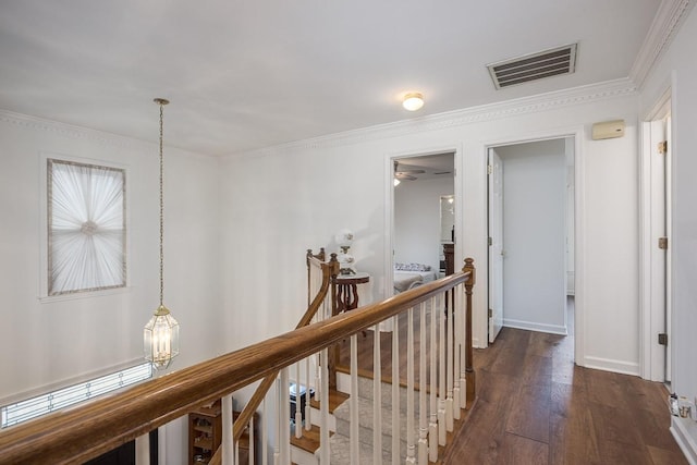 corridor with wood-type flooring, visible vents, ornamental molding, an upstairs landing, and baseboards