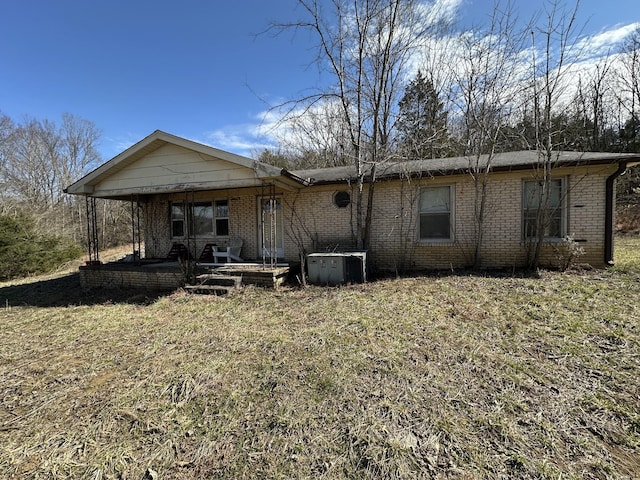 back of property with a yard and brick siding