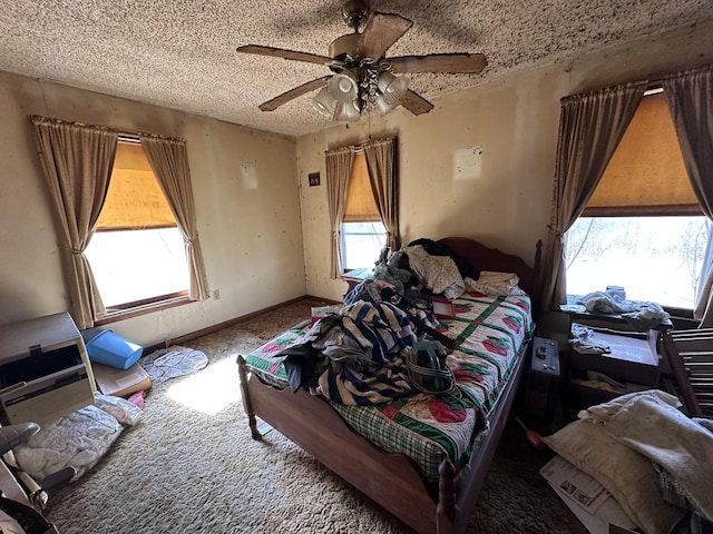 bedroom with carpet floors, a textured ceiling, baseboards, and a ceiling fan