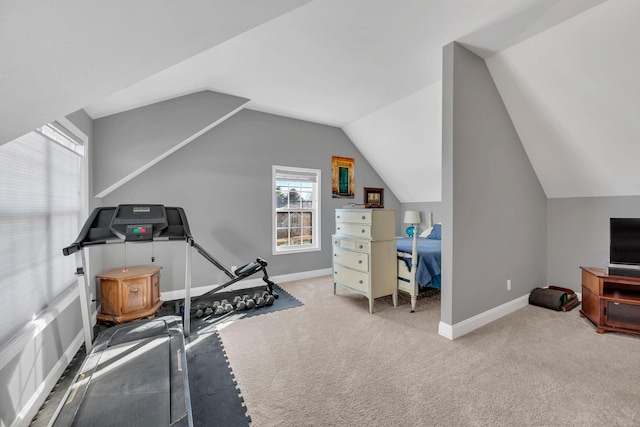 workout room featuring carpet, vaulted ceiling, and baseboards