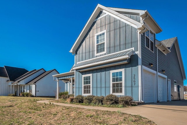 view of front of house featuring board and batten siding, a standing seam roof, metal roof, and concrete driveway