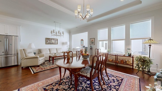 dining room with a chandelier, ornamental molding, and dark wood-style floors