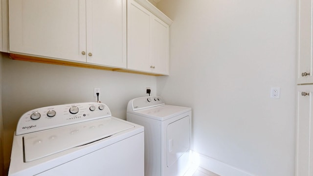 washroom with washing machine and clothes dryer and cabinet space