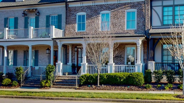 view of front of home with covered porch and brick siding