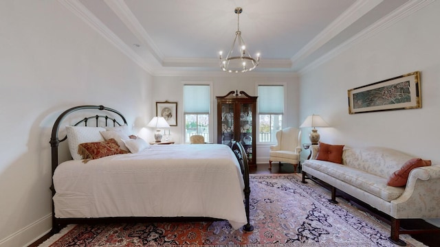 bedroom with a raised ceiling, crown molding, and baseboards