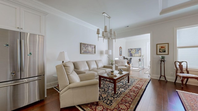 living room featuring baseboards, ornamental molding, dark wood finished floors, and a chandelier