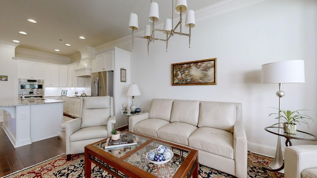 living room with a chandelier, recessed lighting, baseboards, ornamental molding, and dark wood finished floors