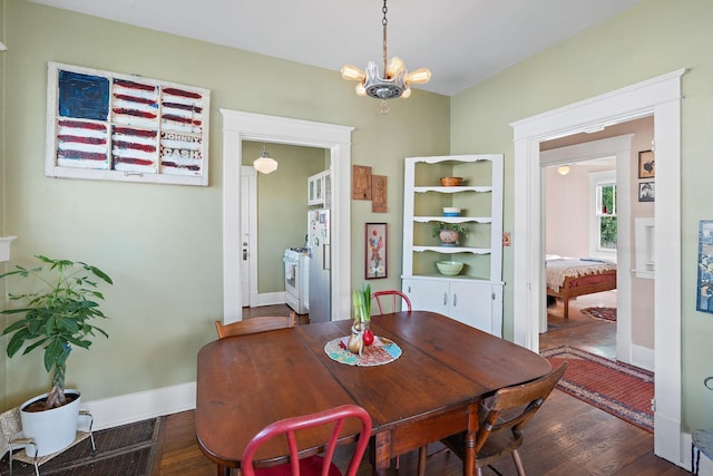 dining area featuring a chandelier, baseboards, and hardwood / wood-style flooring