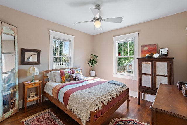 bedroom with dark wood finished floors, a ceiling fan, and baseboards