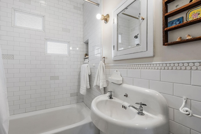 full bath with a wainscoted wall, tub / shower combination, and tile walls