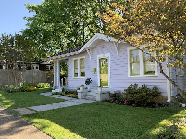 view of front of home featuring fence and a front yard