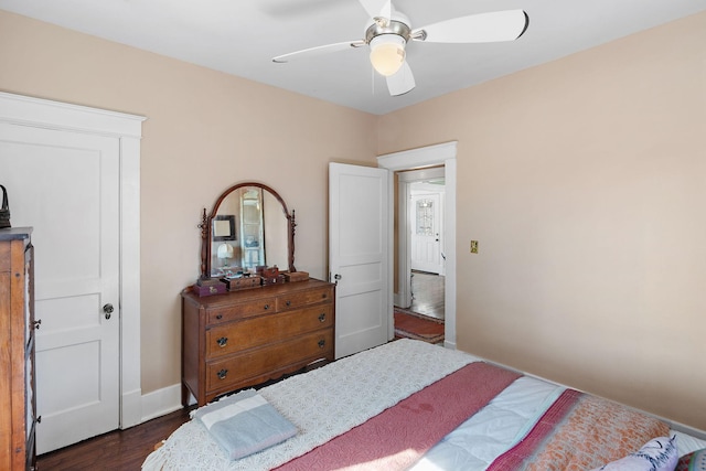 bedroom featuring ceiling fan, baseboards, and dark wood-style flooring