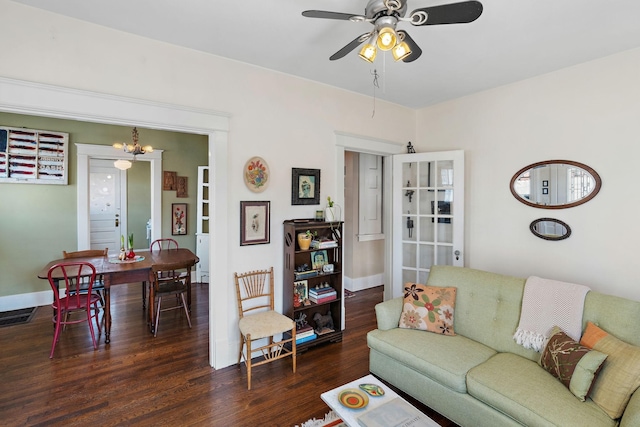 living room with visible vents, ceiling fan, baseboards, and wood finished floors