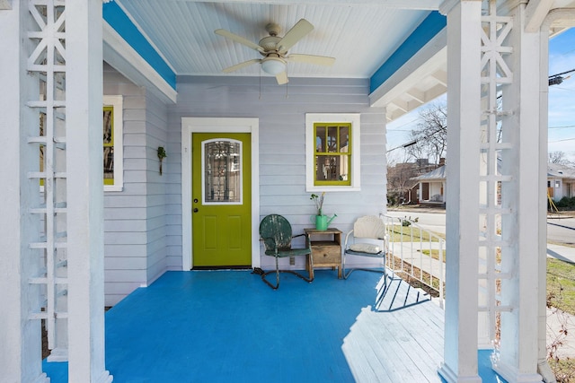 wooden deck featuring covered porch and a ceiling fan