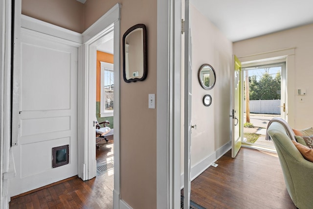 foyer entrance with visible vents, dark wood finished floors, and baseboards