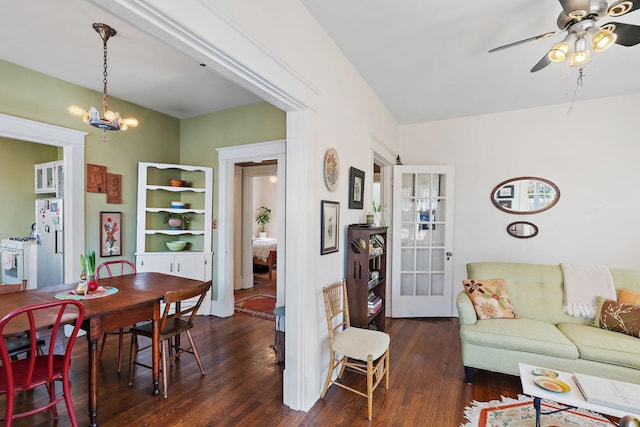 living room with ceiling fan with notable chandelier, french doors, and dark wood-style flooring