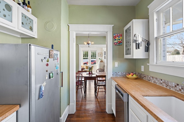 kitchen featuring appliances with stainless steel finishes, glass insert cabinets, a sink, and white cabinetry