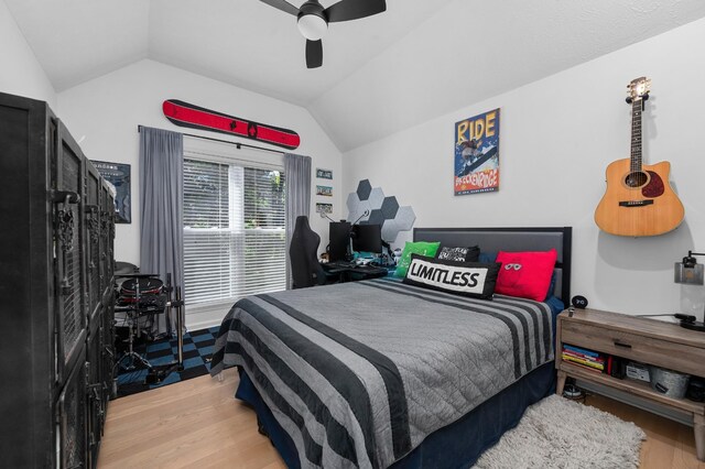 bedroom with lofted ceiling, a ceiling fan, and wood finished floors