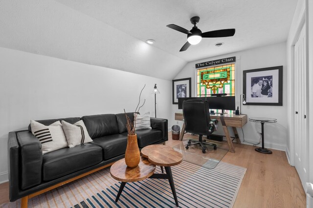 home office with a ceiling fan, baseboards, vaulted ceiling, and light wood finished floors