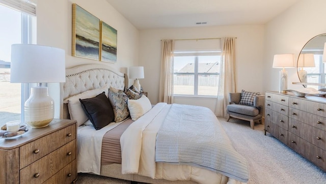 bedroom featuring visible vents and light colored carpet