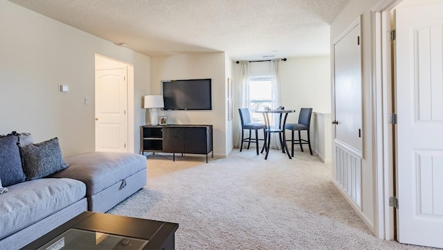 carpeted living room featuring visible vents, a textured ceiling, and baseboards