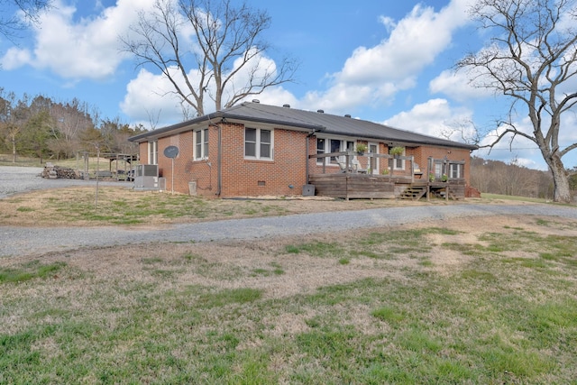 rear view of house featuring central AC unit, brick siding, a yard, crawl space, and a wooden deck