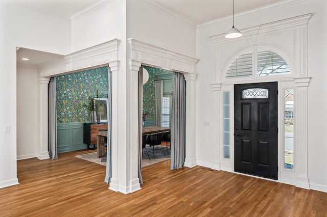 entrance foyer featuring light wood-style floors, a healthy amount of sunlight, and crown molding