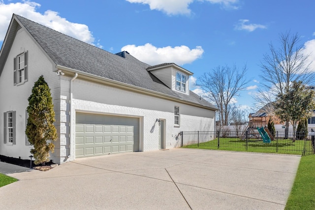 view of property exterior featuring an attached garage, a playground, brick siding, fence, and driveway