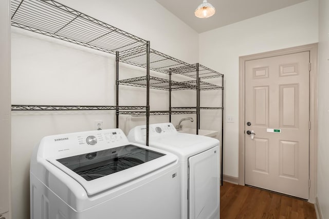 laundry area with a sink, laundry area, washer and clothes dryer, and dark wood-style flooring