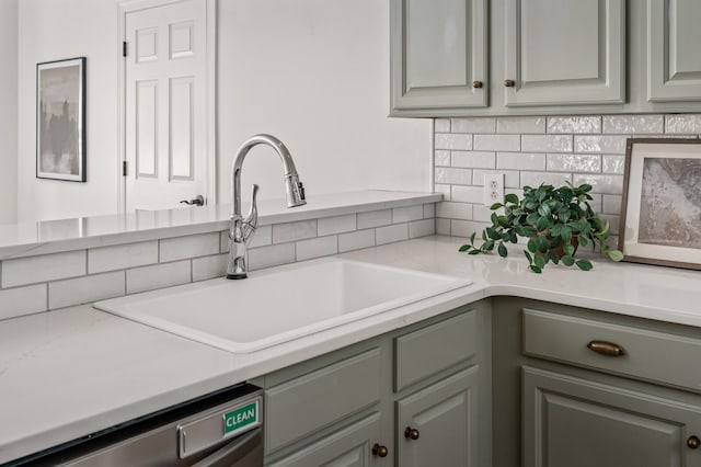 kitchen with dishwasher, backsplash, light countertops, and a sink