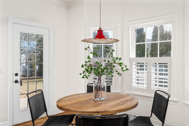 dining space featuring ornamental molding and wood finished floors