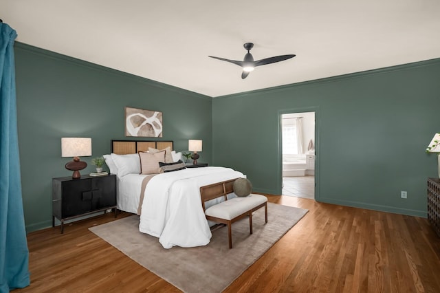 bedroom featuring ornamental molding, wood finished floors, and baseboards