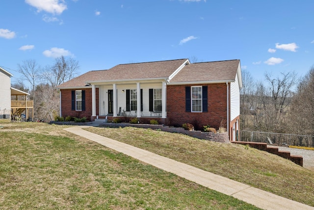 view of front facade featuring a porch, brick siding, and a front lawn