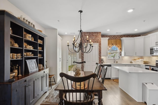 dining space with a chandelier, recessed lighting, and light wood finished floors