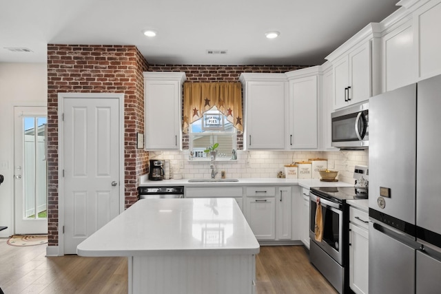 kitchen with stainless steel appliances, visible vents, a sink, and backsplash