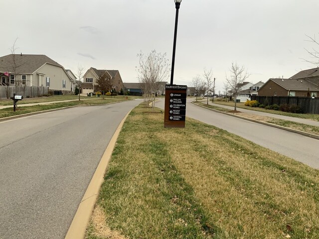 view of street featuring street lighting, a residential view, curbs, and sidewalks