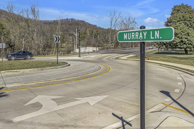 view of road with curbs, traffic signs, and sidewalks