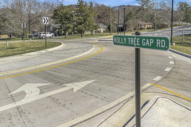 view of street featuring curbs, street lighting, traffic signs, and sidewalks