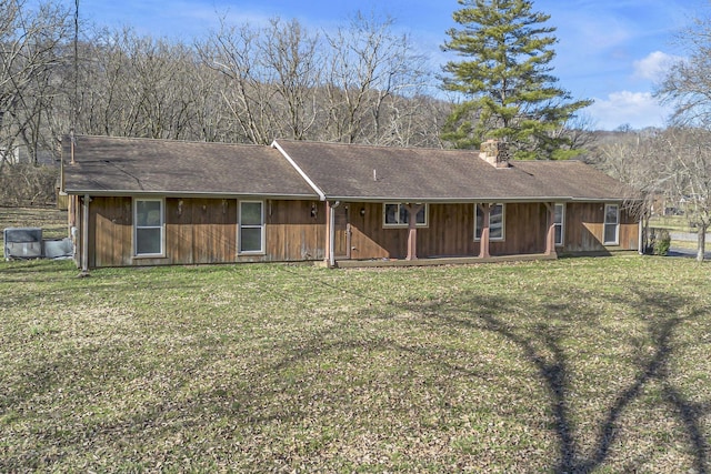 single story home with roof with shingles, a front lawn, and a chimney